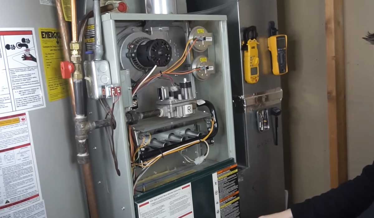 Open residential furnace showing internal components and wiring during HVAC inspection