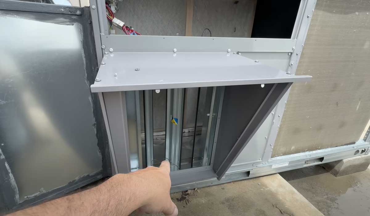 Finger pointing to the damper section inside a rooftop commercial HVAC unit