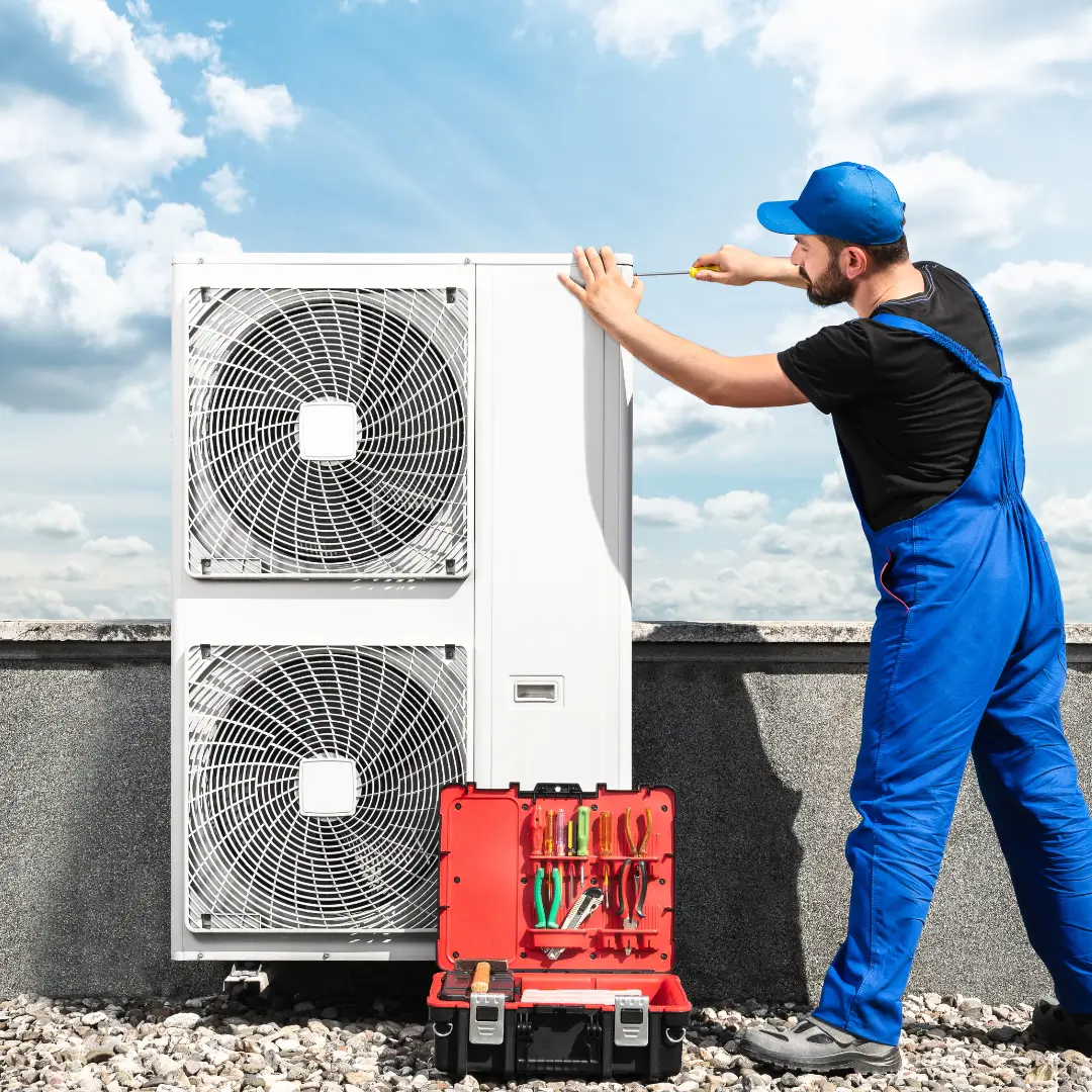 A technician in blue overalls services an AC unit on a rooftop in Fort Worth, TX, with a nearby toolbox full of HVAC tools for expert AC repair.