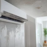 Air conditioner leaking water, causing wall moisture damage from high humidity or condensation issues.