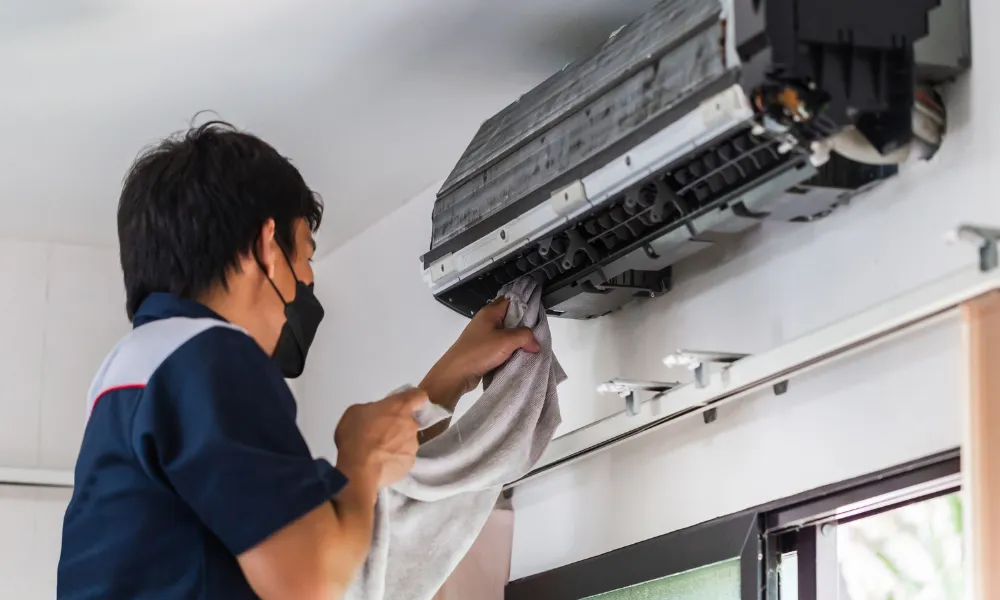 Emergency AC repair in Garland with technician servicing a wall-mounted mini split unit
